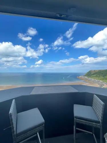 a view of the ocean from a balcony with two chairs at Penthouse Flat in Scarborough in Scarborough