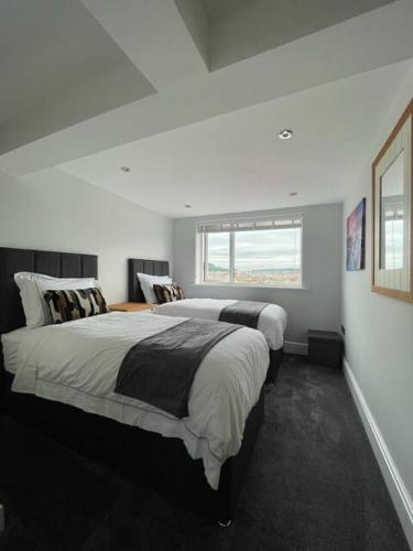 スカーバラにあるPenthouse Flat in Scarboroughのベッド2台と窓のある寝室