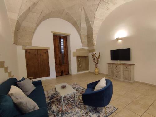 ein Wohnzimmer mit einer blauen Couch und einem Fernseher in der Unterkunft Corte San Gabriele in Galatina