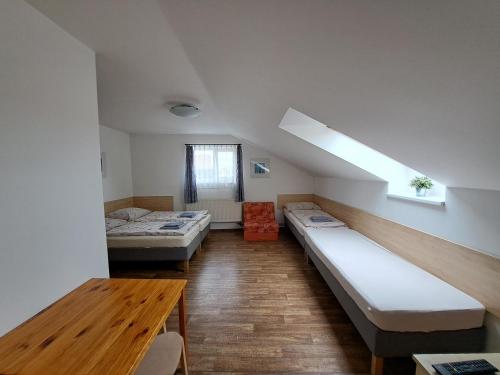 Habitación con 2 camas y mesa. en Penzion u Radů en Hustopeče