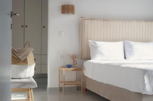 a bedroom with a white bed and a chair at Onar House I in Achladies