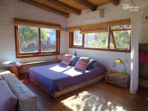 1 dormitorio con 1 cama en una habitación con ventanas en Las Negras en Punta del Diablo
