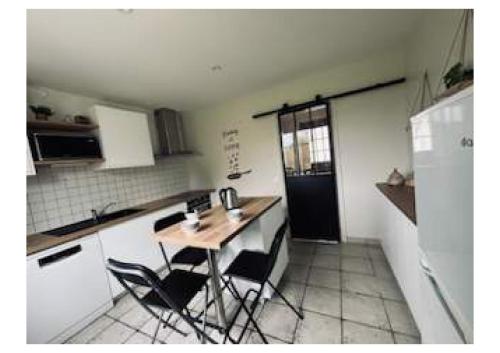 a kitchen with a table and some chairs in it at La Giraudière in Cellettes