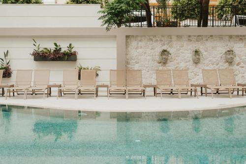 a group of chairs sitting next to a swimming pool at Kleopatra Dreams Beach Hotel in Alanya