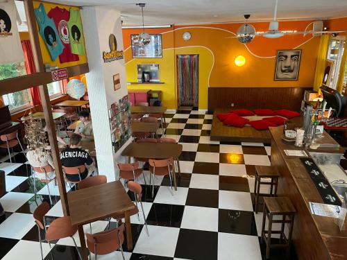 un restaurante con suelo a cuadros en blanco y negro en Sunflower Beach Backpacker Hostel en Rímini