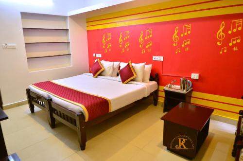 a bedroom with a bed with a red wall at Royal Serene Villas in Ooty