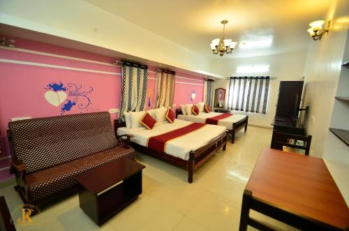 a hotel room with two beds and a table at Royal Serene Villas in Ooty