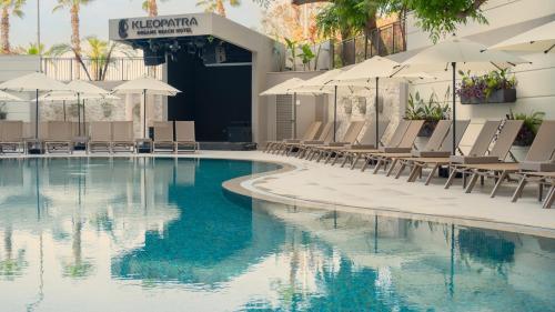 a swimming pool with lounge chairs and umbrellas at Kleopatra Dreams Beach Hotel in Alanya