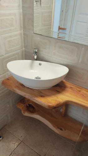a white sink on a wooden table in a bathroom at Konstantina Apartment in Lákka