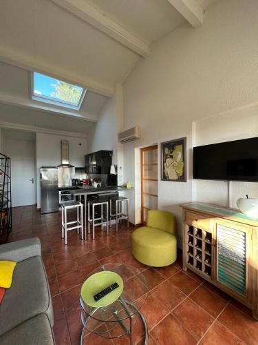 un salon avec un canapé et une cuisine dans l'établissement Appartement vue sur mer, piscine, garage privé, à Bormes-les-Mimosas