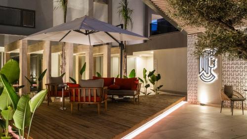 an outdoor patio with chairs and an umbrella at Kleopatra Dreams Beach Hotel in Alanya