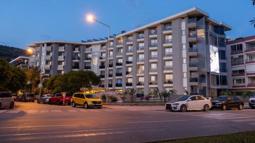 a large building with cars parked in front of it at Kleopatra Dreams Beach Hotel in Alanya