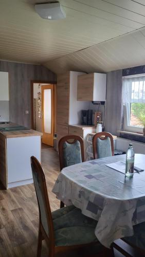 ein Esszimmer mit einem Tisch und Stühlen sowie eine Küche in der Unterkunft Ferienwohnungen Bauernhof Beckmann in Winsen