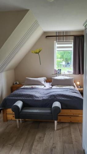 um quarto com uma cama com um edredão azul e uma janela em Ferienwohnungen Bauernhof Beckmann em Winsen