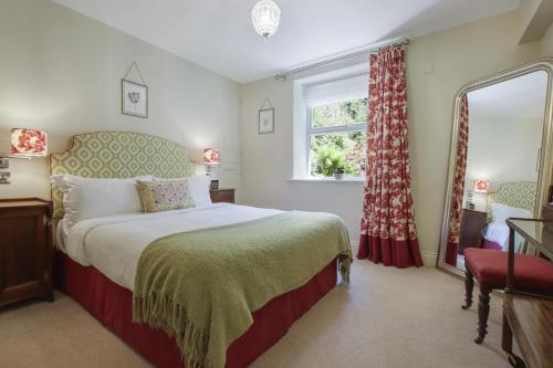 a bedroom with a large bed and a window at The Old Kitchen Exford in Wheddon Cross