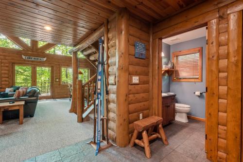 a log cabin with a staircase in a living room at 803 Mountain Cabin in Boyne Falls