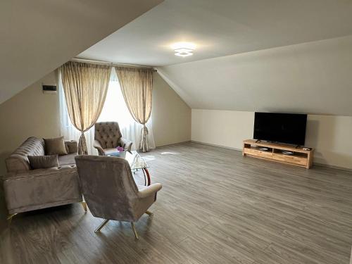 a living room with a couch and a flat screen tv at Casa Cristina in Tuzla