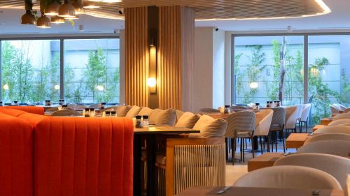 a dining room with tables and chairs and windows at Kleopatra Dreams Beach Hotel in Alanya
