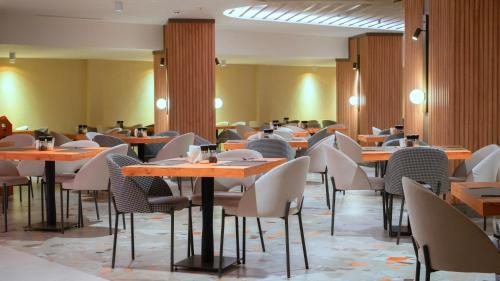 a restaurant with tables and chairs in a room at Kleopatra Dreams Beach Hotel in Alanya
