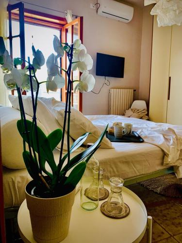 a table with a potted plant on a table with a bed at Vicolo Zenone 8 Casa Esclusiva tra Natura e Arte in Garzano
