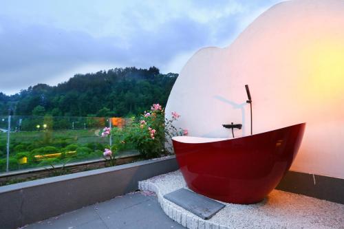a red bath tub sitting on a ledge next to a window at Pure House in Zhangjiajie