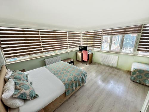 a bedroom with a bed and two windows at Sağıroğlu Otel in Trabzon