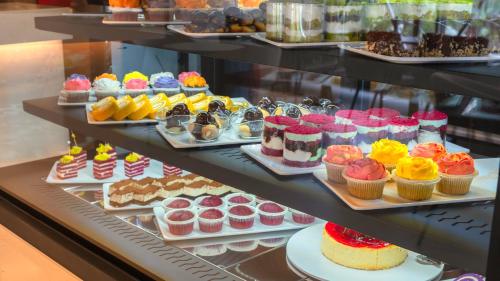 a display case filled with different types of cakes and cupcakes at Kleopatra Dreams Beach Hotel in Alanya