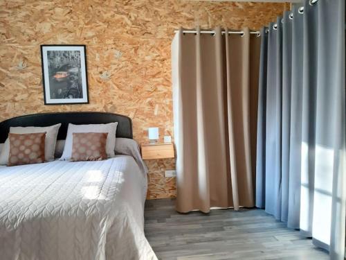 une chambre avec un lit et une fenêtre avec des rideaux dans l'établissement Appartement Au Murmure des Eaux à Fontaine-de-Vaucluse, à Fontaine-de-Vaucluse