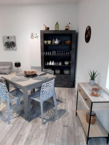 - une salle à manger avec une table, des chaises et une étagère dans l'établissement Appartement Au Murmure des Eaux à Fontaine-de-Vaucluse, à Fontaine-de-Vaucluse