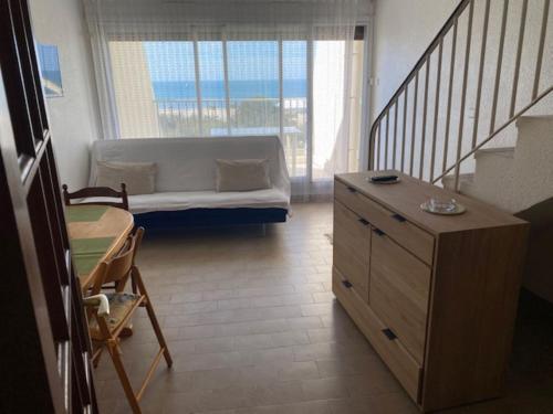 un petit salon avec un canapé et une table dans l'établissement Vittoria immobilier - VUE MER ET GRANDE TERRASSE- Chèques Vacances acceptés, à La Grande Motte