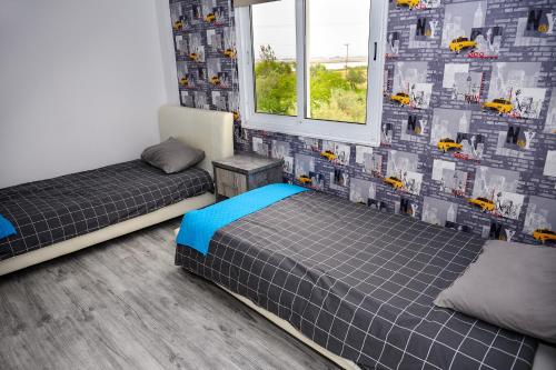 a bedroom with two beds and a wall with cars on it at Demetris apartment in Meneou