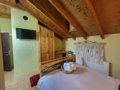 - une chambre avec un lit et une télévision murale dans l'établissement Vila118, à Voskopojë