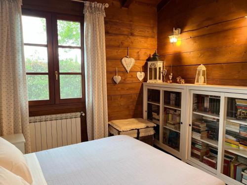 a bedroom with wooden walls and a bed and a window at Casa Fabiani - Vacanza in Toscana - via Francigena - Pet Friendly in Orentano