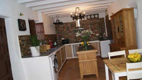 a kitchen with a white refrigerator and a table with a counter at Casa rural los Cerezos in Albox