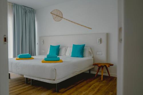 1 dormitorio con cama blanca y almohadas azules en Villa Relajares, en Lajares