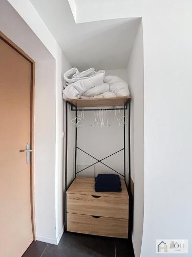 - une étagère avec des serviettes blanches dans l'établissement Appartement « Marine Serenity » - 50m de la plage, à Bray-Dunes