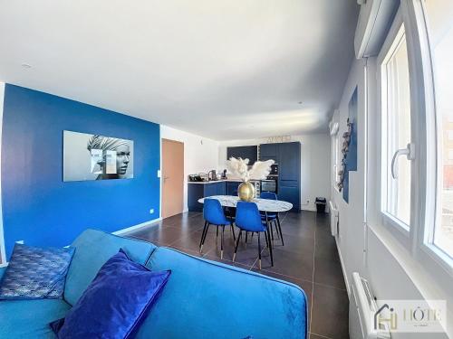 a living room with a blue couch and a table at Marine Serenity - Appartement à 50m de la plage in Bray-Dunes