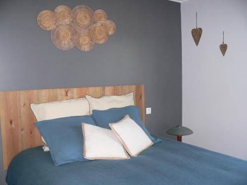 a bedroom with a blue bed with two pillows at La petite chambre du lac in Carcassonne
