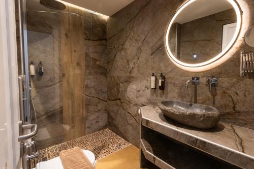 a bathroom with a sink and a mirror at Royal Hotel and Suites in Polychrono