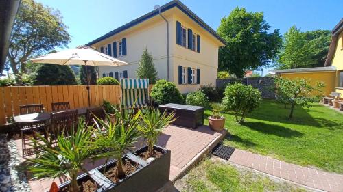 a backyard with a table and an umbrella at Bei Ziegers Ferienhaus in Wustrow