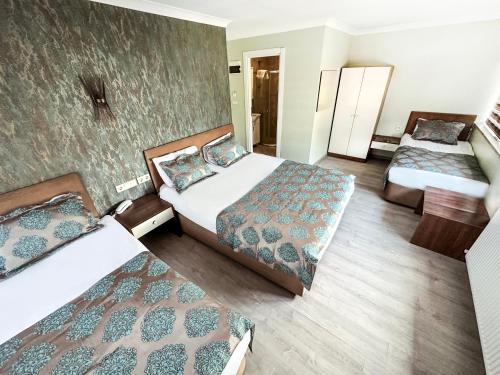 ein Hotelzimmer mit 2 Betten und 2 Betten sidx sidx sidx sidx in der Unterkunft Sağıroğlu Otel in Trabzon