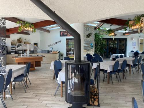 een restaurant met tafels en stoelen en een open haard bij Hôtel Spa L'Ermitage in Les Salles-sur-Verdon