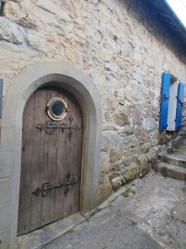 - une porte en bois sur le côté d'un bâtiment en pierre dans l'établissement Penty en plein coeur de Morgat, à Crozon