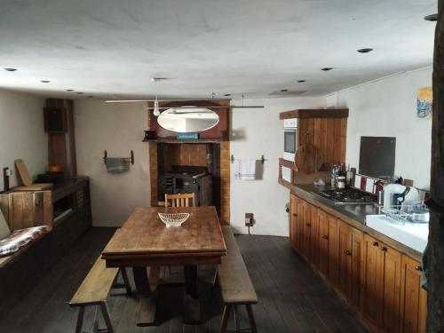 une cuisine avec une table en bois au milieu dans l'établissement Penty en plein coeur de Morgat, à Crozon