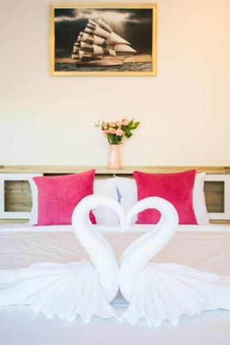 two white swans forming a heart on a bed at Fora Boutique Hotel in Karon Beach