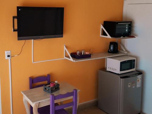 Habitación con mesa, TV y microondas. en Alojamiento céntrico en Puerto Madryn