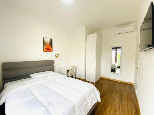 a bedroom with a large white bed and a window at Marco Polo House in Mestre