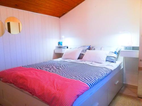 Dormitorio pequeño con cama con manta a rayas en Felix Apartment Biograd, en Biograd na Moru