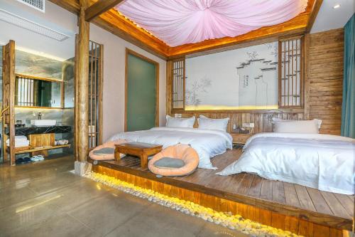 a bedroom with two beds and a large window at Pure House in Zhangjiajie