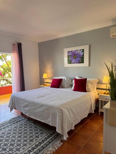 1 dormitorio con 1 cama blanca grande con almohadas rojas en Casa Concha - Peaceful and Relaxing en Lagos